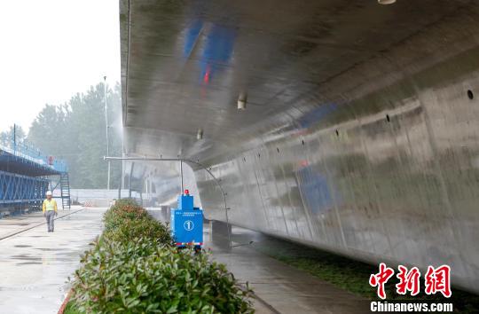 圖為,自動噴淋養護小車在對箱梁進行養護作業。箱梁養護是保證箱梁質量的關鍵環節,中鐵十一局自主研發了箱梁自動噴灑系統,實現了箱梁的全自動、全方位養護。 徐云華 攝